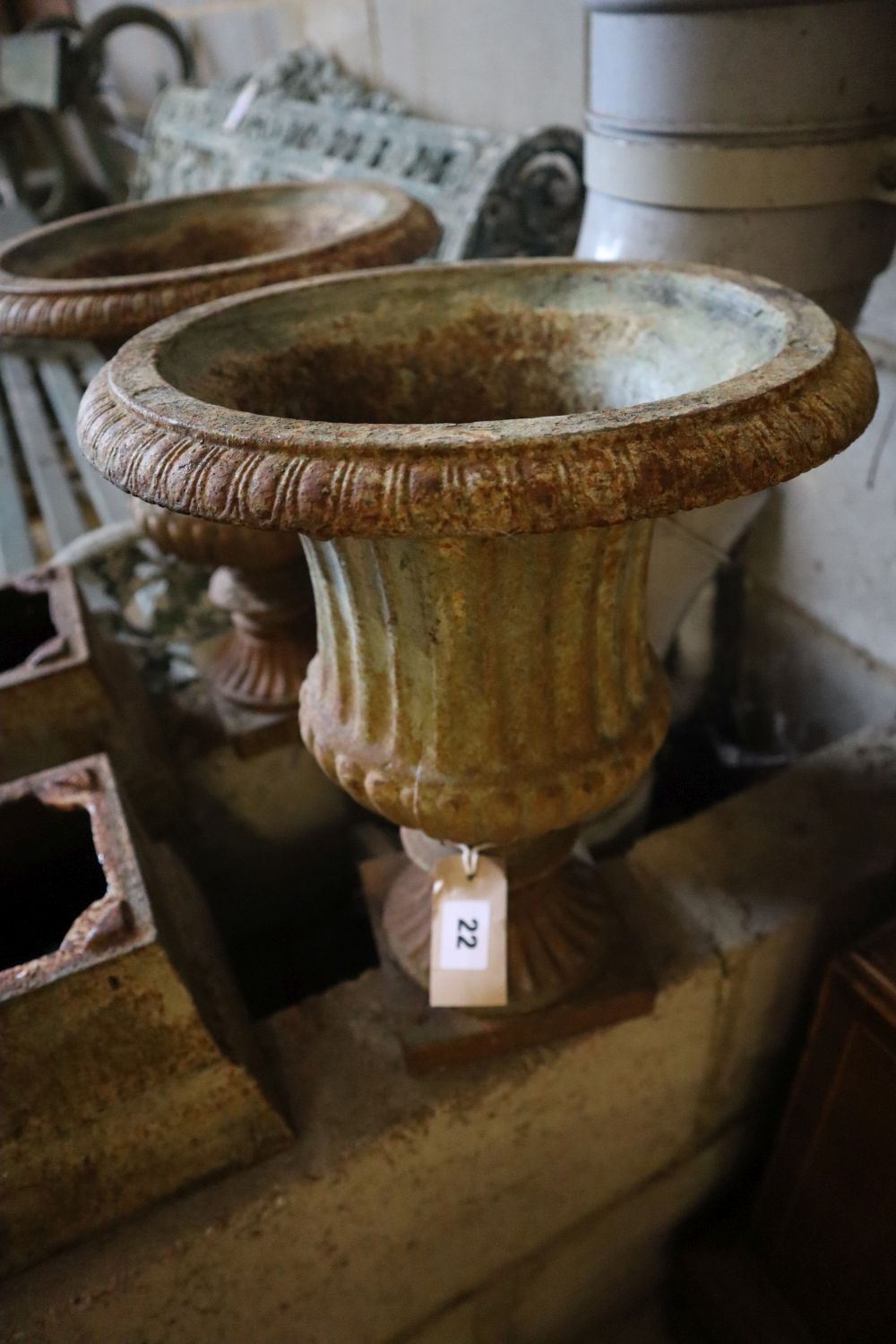 A pair of Victorian style cast iron campana garden urns on stands, height 49cm